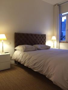 ein Schlafzimmer mit einem großen Bett mit zwei Lampen in der Unterkunft GITE MAISON WEEK END in Dunkerque