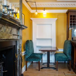 uma sala de jantar com uma mesa e cadeiras e uma lareira em Grassington House em Grassington