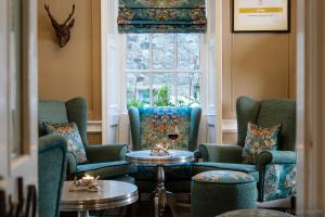 a room with chairs and a table and a window at Grassington House in Grassington