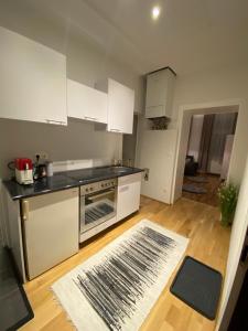 Il comprend une cuisine avec des appareils électroménagers blancs et du parquet. dans l'établissement Paower Apartment, à Vienne