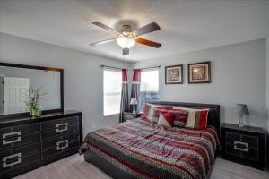 una camera da letto con un letto e un ventilatore a soffitto di EXCELLENT 7 Bedroom EIR Vacation Villa - PRIVATE POOL a Kissimmee Altre 43 foto