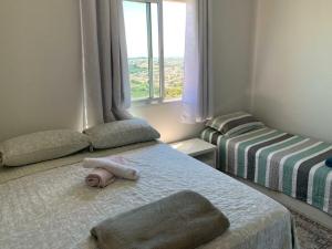 um pequeno quarto com 2 camas e uma janela em Sunset em Ponta Grossa