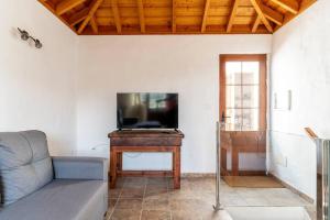 ein Wohnzimmer mit einem Sofa und einem Flachbild-TV in der Unterkunft Casa Barreros in Arecida