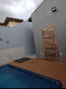 una piscina vuota con porta in legno accanto a un edificio di Recanto Caldeira a Olímpia