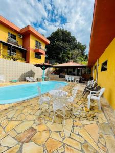 a patio with chairs and a swimming pool at Residencial Vista Bela in Bombinhas