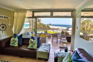 a living room with a couch and a view of the ocean at Sands Beach Breaks Beach Front Ballito in Ballito