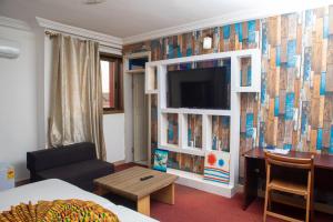 a hotel room with a tv and a living room at RIDMA HOTEL in Accra
