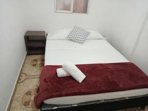 1 dormitorio con cama blanca y manta roja en apartamento family the luxe en Santa Rosa de Cabal