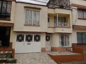 ein großes Haus mit weißen Türen und einem Balkon in der Unterkunft apartamento family the luxe in Santa Rosa de Cabal