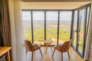 ein Zimmer mit Stühlen, einem Tisch und einem großen Fenster in der Unterkunft Marlo Ayvalık 12 Plus Adult Only in Ayvalık