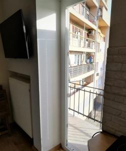 a room with a window and a tv and a balcony at Angela Studio Apartments in Zagreb
