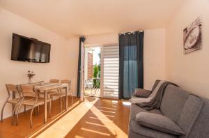 a living room with a table and chairs and a television at Oasis in Gąski