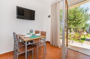 une salle à manger avec une table, des chaises et une télévision dans l'établissement Oasis, à Gąski