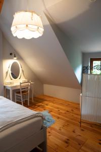 - une chambre avec un lit, une table et un miroir dans l'établissement DOM NA GROBLI, à Dłużki