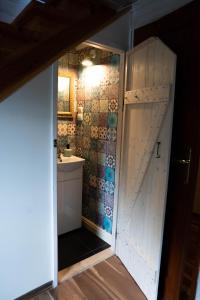 een badkamer met een deur naar een wastafel bij DOM NA GROBLI in Dłużki
