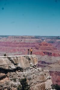 two people standing on top of a rock looking at a mountain at Wander Camp Grand Canyon in Valle