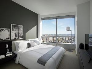 a bedroom with a large white bed and a large window at AKA University City in Philadelphia