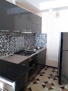 a kitchen with black cabinets and a stove top oven at G21 in Batumi