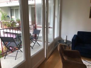 a living room with a couch and chairs and a balcony at 75 m2 # logia & parking gratuit # BESTOFBLO 4 # in Fontainebleau