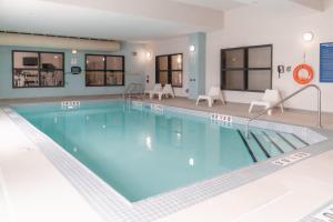 a large pool with blue water in a hotel room at Stars Inn in Leduc