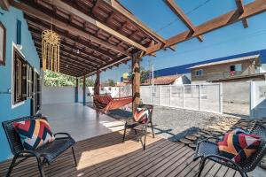 a porch with chairs and a wooden deck at Casa na praia de Morrinhos Bombinhas para 10 pessoas, Excelente localização in Bombinhas