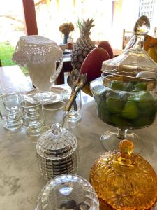a table topped with glasses and other glass items at Pouso da Ermelinda in Tiradentes +51 photos