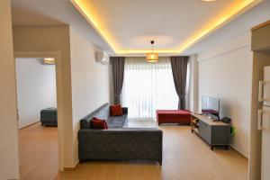 a living room with a couch and a tv at Çetkin Exclusive Apart in Fethiye