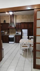 una cocina con armarios de madera y una mesa con sillas. en Casa rural el Burro, en Agüimes