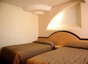 Habitación con 2 camas y luz en Porto Novo Hotel & Suites, en Ciudad de México