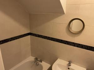 uma casa de banho com uma banheira, um WC e um espelho. em Chatsworth - Large Apartment Near Newcastle City Centre em Saint Peters