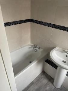 uma casa de banho com uma banheira e um lavatório em Chatsworth - Large Apartment Near Newcastle City Centre em Saint Peters