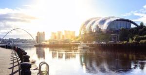 a view of a river with a building and a city at Chatsworth - Large Apartment Near Newcastle City Centre in Saint Peters