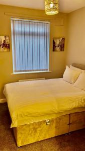 a large bed in a bedroom with a window at Chatsworth - Large Apartment Near Newcastle City Centre in Saint Peters