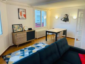 a living room with a couch and a table at Charmant appartement de cœur de ville - 2 chambres lits Queen size - NETFLIX - WIFI in Cherbourg en Cotentin