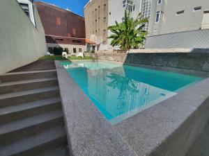 a swimming pool with stairs next to a building at MyStay Porto Bolhão - Pool & Garden in Porto