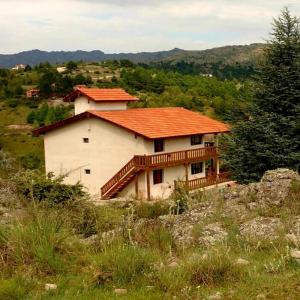 una casa con techo naranja en una colina en La Ponderosa Cumbrecita en La Cumbrecita