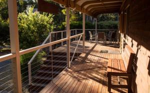a wooden deck with a table and chairs on it at Ellimata Holiday Cottage in Halls Gap