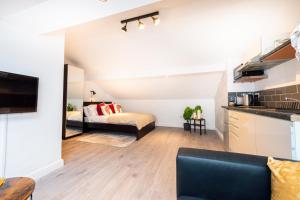 een keuken en een woonkamer met een bed in een kamer bij The Blossoms Studio Apartments in Liverpool