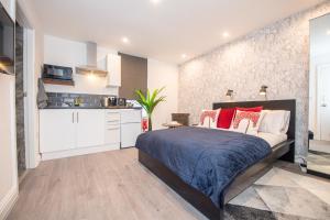 a bedroom with a large bed and a kitchen at The Blossoms Studio Apartments in Liverpool