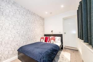 una camera da letto con un letto con cuscini rossi di The Blossoms Studio Apartments a Liverpool
