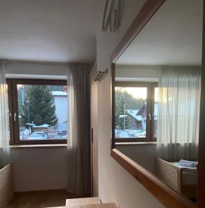 a bathroom with a large mirror and a window at Hotel Pizboè in Mazzin