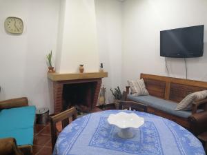 a living room with a table and a couch and a tv at Casa do Bonifácio in Vilarinho