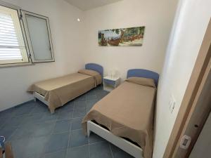 a room with two beds and a window at Villa Alice in Santo Stefano di Camastra