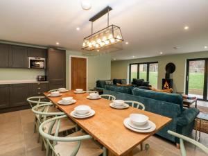 uma cozinha e sala de estar com uma mesa de madeira e cadeiras em The Gully em Sherborne