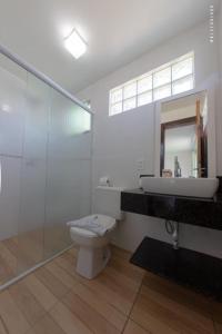 uma casa de banho com um WC, um lavatório e um espelho. em Pousada Praia da Lagoinha em Bombinhas