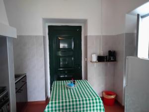 Lajes das FloresにあるMoradias Estação Radio Naval , Moradia Vila do Portoの小さな部屋で、緑のドアのあるテーブルが備わります。