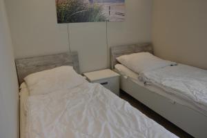 1 dormitorio con 2 camas y mesita de noche al lado en Meerblick FeWo Nr A-107 en Sierksdorf