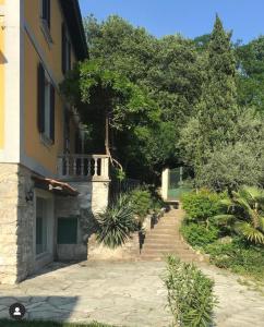 eine Treppe, die zu einem Gebäude mit Bäumen im Hintergrund führt in der Unterkunft Villa Monte Bianco in Mandello del Lario