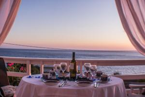 a table with a bottle of wine and glasses on the beach at Villa Sea Breeze in Karpathos