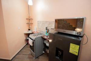 a small kitchen with a microwave on top of a refrigerator at APARTAMENTO PIRÁMIDES in San Juan Teotihuacán